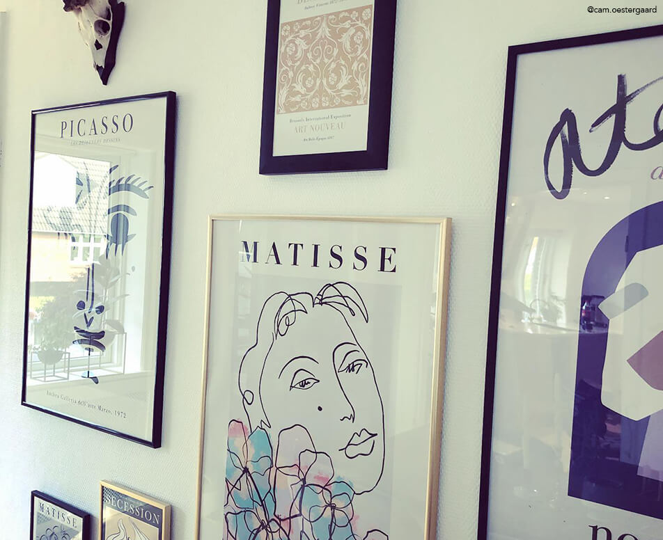 Стена с картини с черни и златни рамки