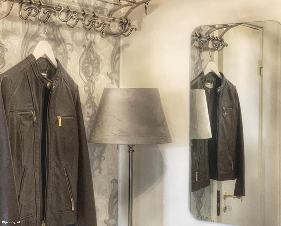 Интериор на коридор – закачалки от метал, правоъгълно огледало и сива лампа