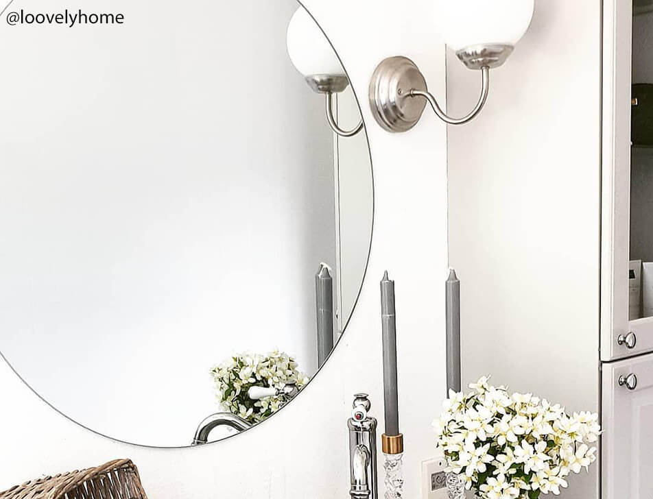 Кръгло огледало, цветя и светлина в баня